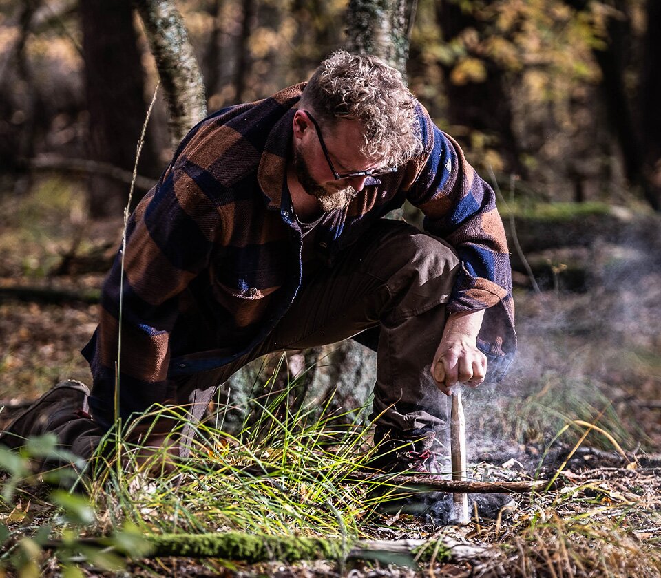 Man doet bushcraft in het bos